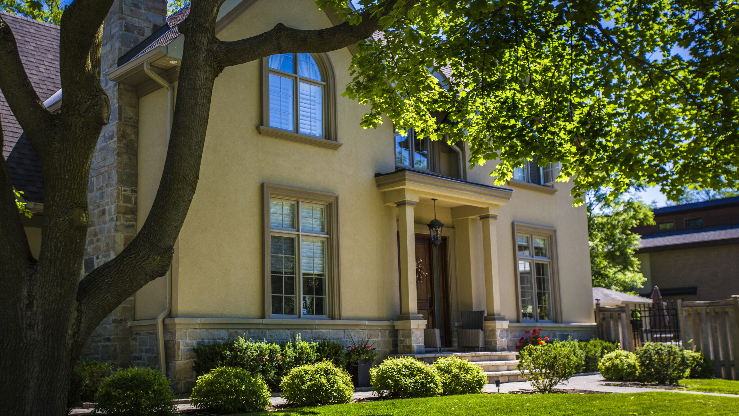 Two storey home with stone accents beneath a mature maple tree in Mineola, Mississauga
