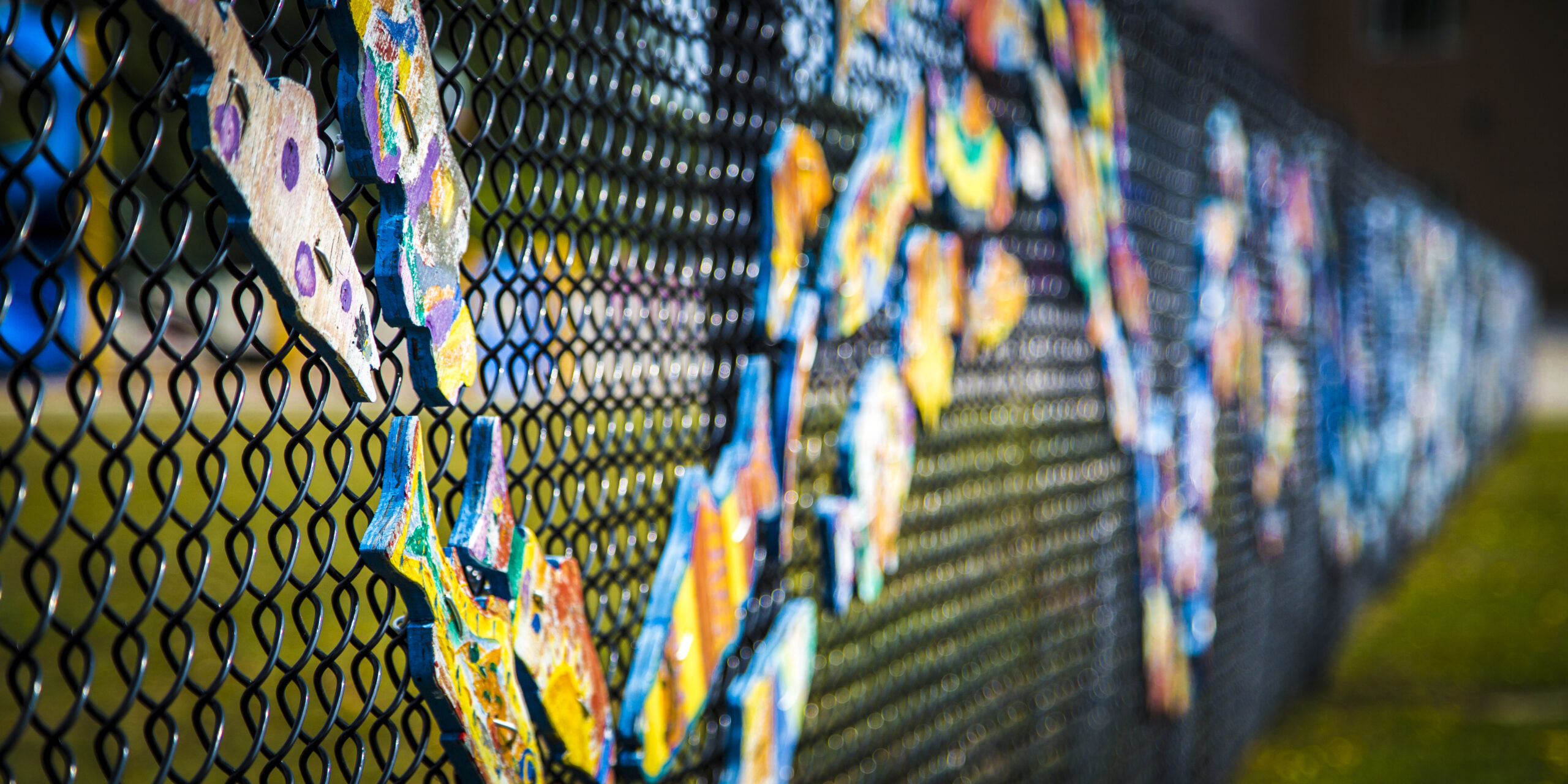 Colourful outdoor art display on a chain link fence in Winston Park, Oakville, Ontario