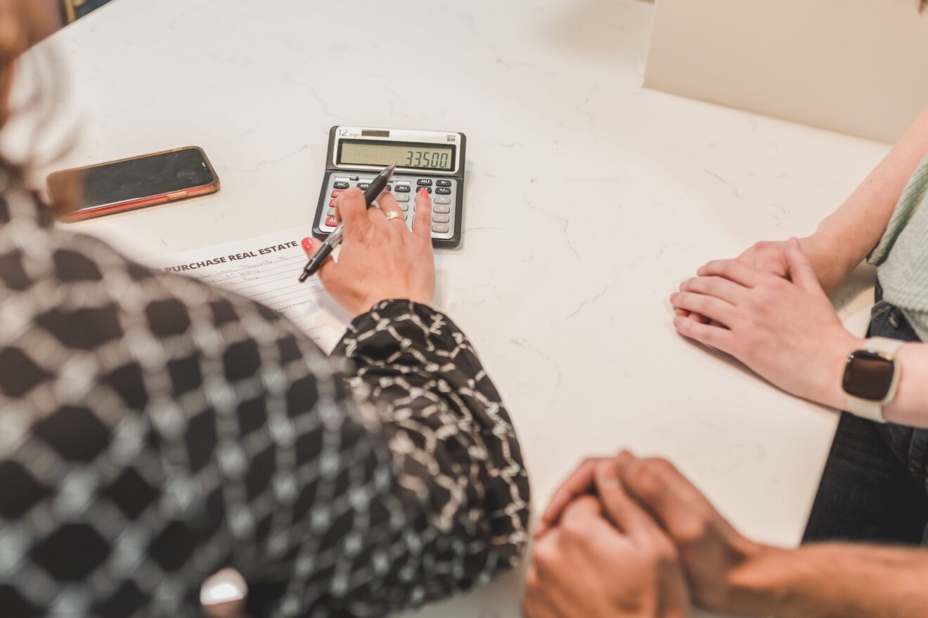 A buyer meeting with a real estate professional and using a calculator to plan closing costs in Ontario