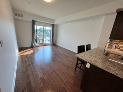 Living room with balcony access and natural light, Suite 319, Windows on the Green, Erin Mills, Mississauga